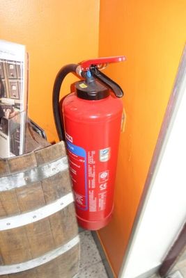 un extincteur à côté d'un fût de vin
