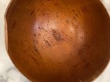 a wooden bowl sitting on a marble counter top