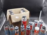 de nombreuses bombes de peinture posées par terre à côté d'un carton contenant des bombes