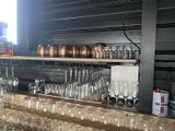 bottles and glasses are lined up on a shelf in a bar