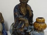 three figurines of a man and a woman sitting next to each other