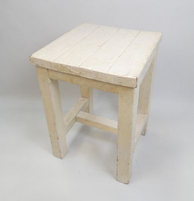 une image représentant un petit tabouret en bois blanc sur fond blanc