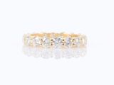 a close up of a yellow gold ring with three diamonds