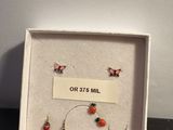 une boîte blanche contenant quatre paires de boucles d'oreilles et une étiquette sur laquelle est inscrit « Or 37's Mill »