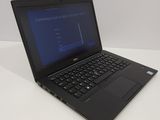 laptop computer sitting on top of a white table with a blue screen