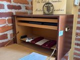 a wooden desk with a clock on top of it next to a brick wall