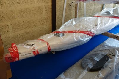 un sac de provisions emballé dans du plastique posé sur une table bleue