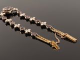 a close up of a rosary with a cross on a black surface