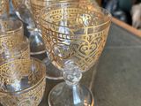 many glasses sitting on a table next to a pitcher