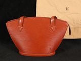 un sac à main Louis Vuitton orange à côté d'un sac beige