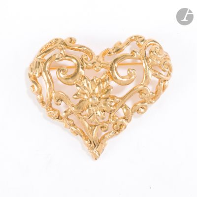 une image représentant une broche dorée en forme de cœur sur fond blanc