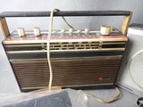an old radio sitting next to a speaker on a table