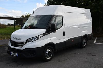 la camionnette blanche est garée sur le parking à côté des arbres