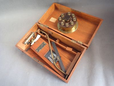 une boîte en bois contenant des outils, posée sur une surface blanche