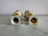 pair of gold and silver vases on a marble counter top