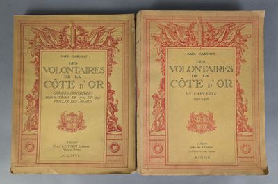 two old books are sitting side by side on a table