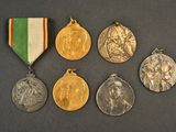 four medals of different sizes and colors are displayed on a black surface