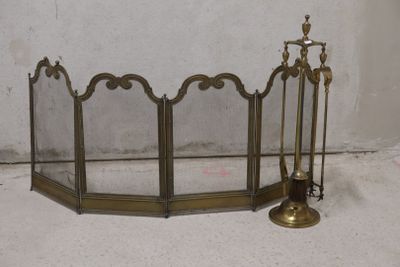a fireplace screen with candles and a candle holder on the floor