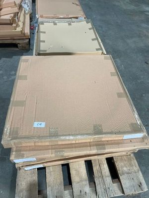 Plusieurs palettes de carton sont empilées sur des palettes dans un entrepôt