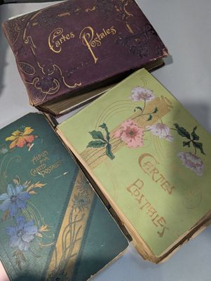 Trois vieux livres sont posés sur une table, à côté d'une tasse de café