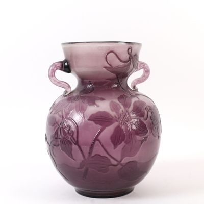 un vase en verre violet orné d'un motif floral