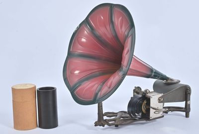 un gramophone rouge et noir posé à côté d'un rouleau de papier toilette