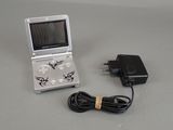 a small game console with a charger and a power cord