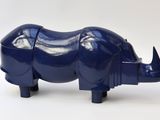 a blue rhino figurine sitting on a white surface