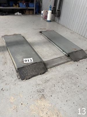 une photo d'une rampe dans un garage sur laquelle est posée une plaque d'immatriculation