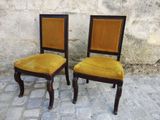 two chairs sitting next to each other on a cobblestone floor
