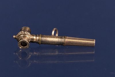 une image représentant une petite pipe en laiton munie d'un manche en métal