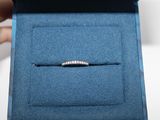 Quelqu'un tient une bague dans une boîte bleue, ornée d'un diamant.