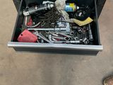 a drawer full of tools on the floor next to a person