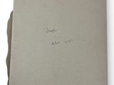 an old book with writing on it sitting on top of a white surface