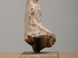 a stone sculpture of a person standing on a block