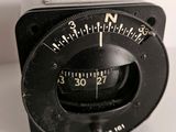 un gros plan d'une horloge analogique noire posée sur une surface blanche