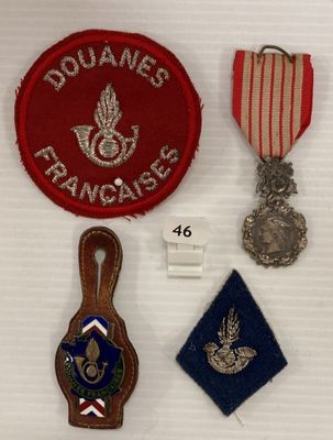 trois médailles et une médaille sont exposées sur un support blanc