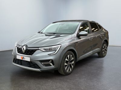 a grey car is parked in a room with a white wall