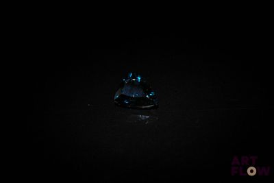 un gros plan sur un diamant bleu dans l'obscurité