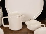 many white plates and cups on the table