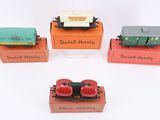 four toy trains sitting on top of each other on a white surface