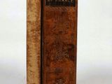 an old book sitting on top of a white table next to a book