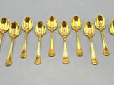 six gold spoons are lined up in a row on a table