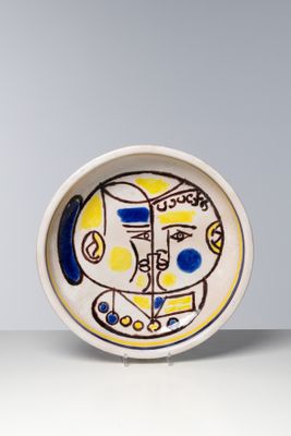 une photo d'une assiette décorée d'une peinture, posée sur une table