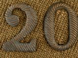 a close up of a metal number on a brown cloth