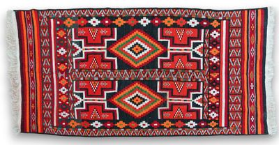 a red and black rug with geometric designs on it