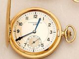 a close up of a gold pocket watch with a chain