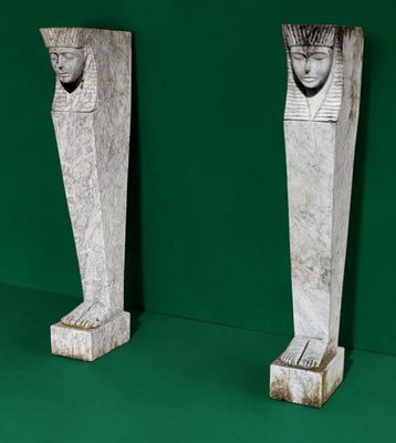 two statues of a man and a woman on a green surface