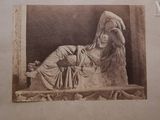 an old photo of a woman laying on a bench with her hands on her head