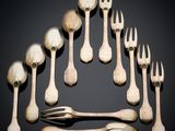 several forks and spoons are arranged in a circle on a black surface